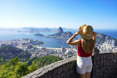 Rear view of woman standing against mountain