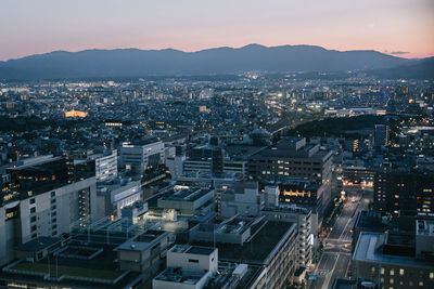 High angle view of illuminated city buildings against sky