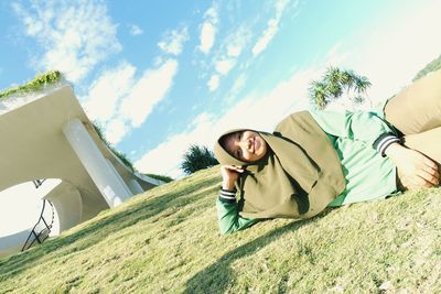 Full length of woman lying down on land against sky