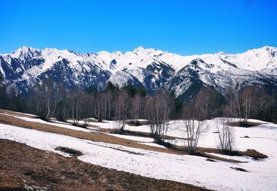 Scenic view of snowcapped mountains against blue sky