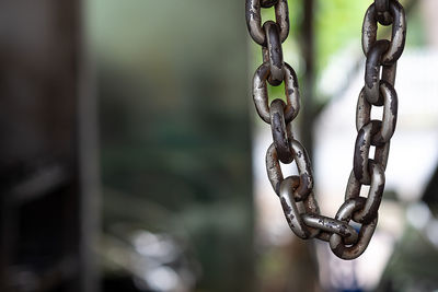 Old metal chains hanging on the ceiling with blurred background.