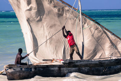 Fishermen sailing in boat on sea