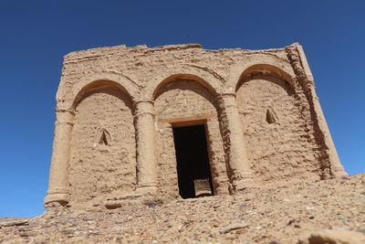 Low angle view of old building against clear blue sky