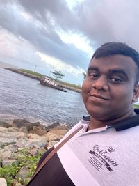 Portrait of young man against sea