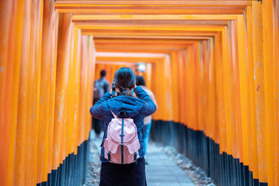 Rear view of man standing by temple against building