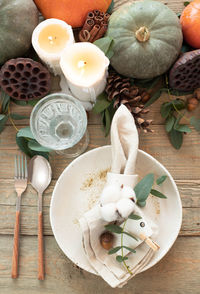 Autumn table decor. table setting with eucalyptus branches, pumpkins, cones and nuts, 