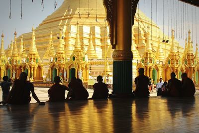 Group of silhouette people sitting at temple