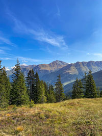 Scenic view of landscape and mountains against blue sky