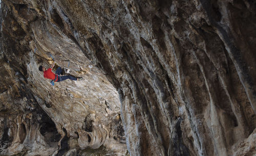 Climber sending a hard sport climbing route in a cave.