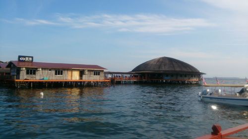 Built structure by sea against sky