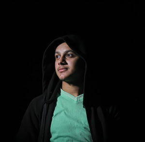 Portrait of mid adult man against black background