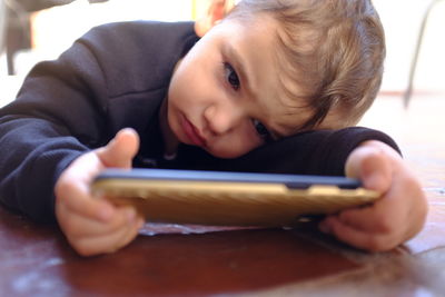 Close-up portrait of boy using mobile phone