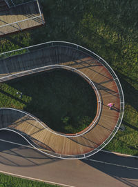 Russia, aerial view of woman walking along winding boardwalk