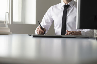 Midsection of man with umbrella on table