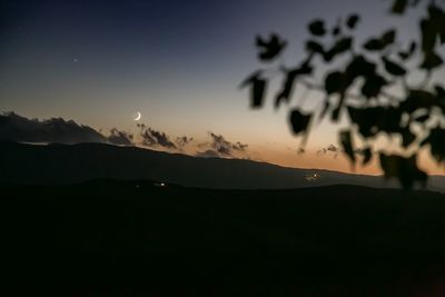 Scenic view of silhouette mountains against sky at night