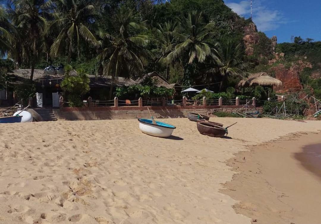 BOATS MOORED AT BEACH AGAINST SKY