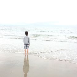 Rear view of boy standing on beach