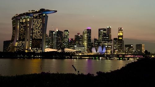 Illuminated city at waterfront in singapore