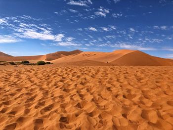 Sand dunes in desert against sky