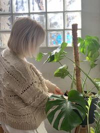 Rear view of woman with potted plants