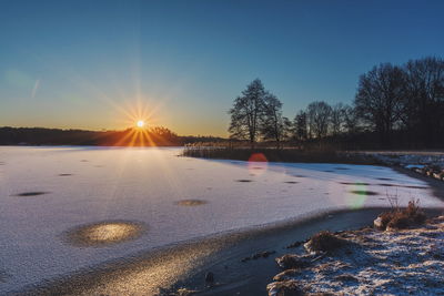 Scenic view of frozen lake against clear sky during winter