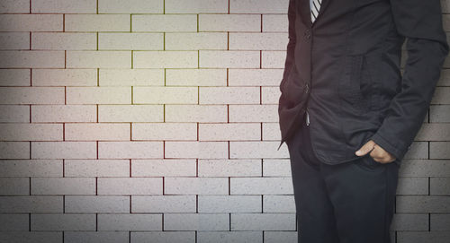 Man standing against brick wall