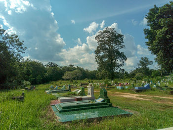 Park bench on field against sky