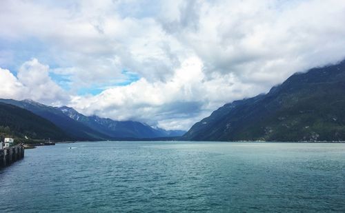 Scenic view of sea and mountains against sky