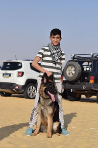 Egyptian young teen boy at the desert camping with his dog at faiuom fayoum fayum lake