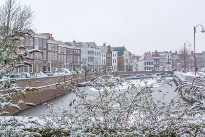 Buildings in city against clear sky during winter