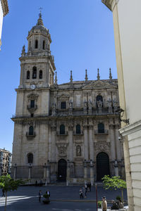 People in historic building against clear sky