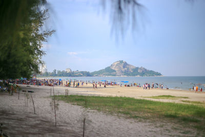 People at beach against sky