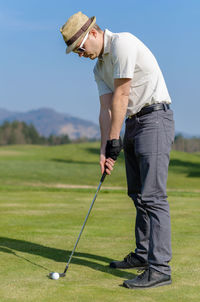 Full length of man playing guitar on golf course