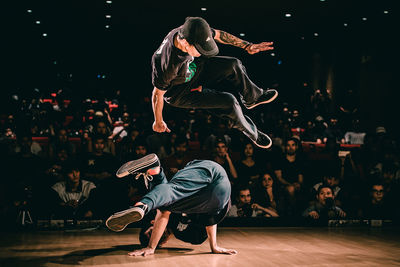 Rear view of people dancing on stage at night