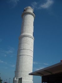 Low angle view of smoke stack against blue sky