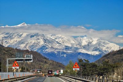 Road leading towards mountains against sky