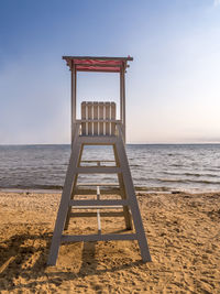 Empty wooden lifeguard post shot against the sea with clear blue sky