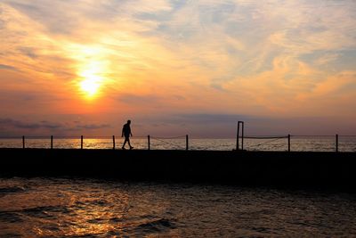 Silhouette of pier at sunset