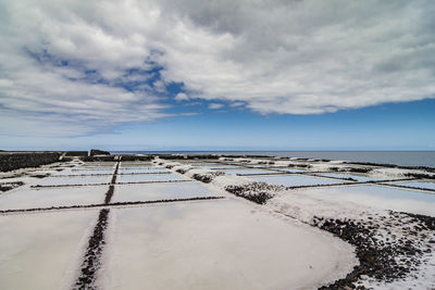 Scenic view of salt pan against sky