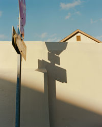 Low angle view of cross on building against sky