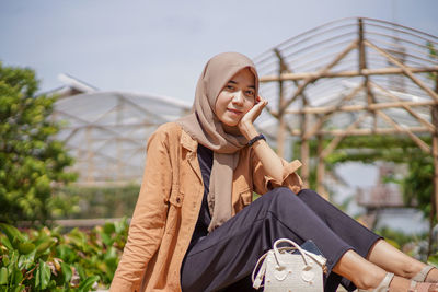 Muslim woman sitting hands placed on her cheeks