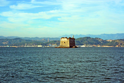 View of lighthouse by sea against sky