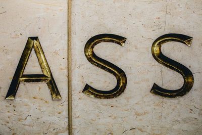 Close-up of ass text on wall