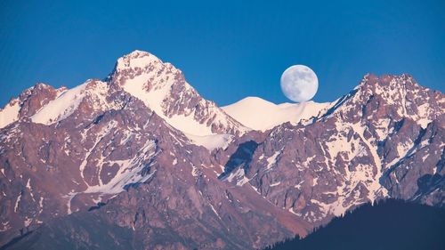 Scenic view of snowcapped mountains against clear blue sky