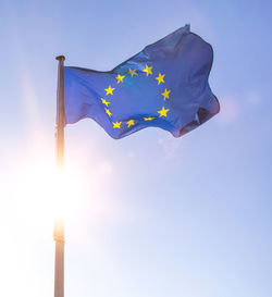 Low angle view of flag against blue sky