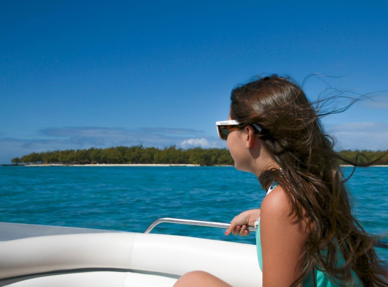 water, sea, young adult, leisure activity, nautical vessel, transportation, lifestyles, blue, mode of transport, headshot, boat, person, young women, clear sky, vacations, sunglasses, sitting, travel