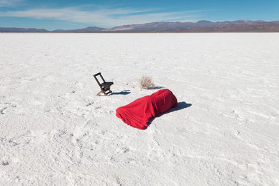 Person wrapped in fabric lying on salt flat