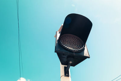 Low angle view of road signal against clear blue sky