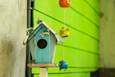 Close-up of birdhouse hanging against wall of house