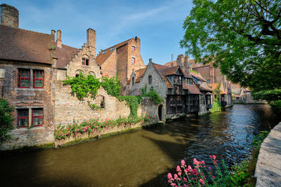 Buildings by canal against sky